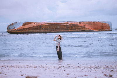 Woman standing on pangandaran beach against sky