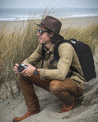 Man looking at camera while sitting on land