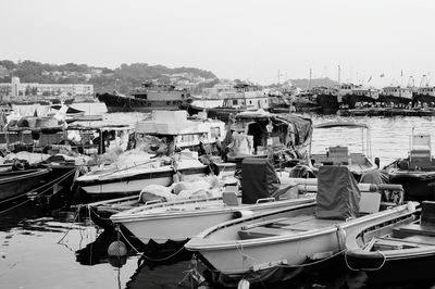 Boats moored at harbor against clear sky