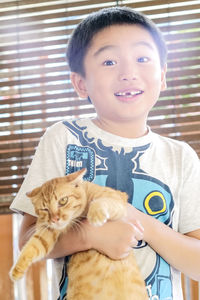 Portrait of cute boy with cat