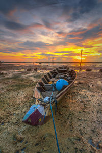 Deck chairs on field against dramatic sky during sunset
