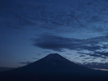 Scenic view of snowcapped mountain against cloudy sky