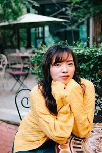 Portrait of young woman sitting on seat