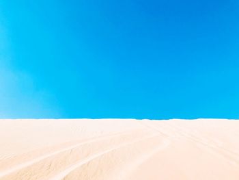 Scenic view of desert against clear blue sky