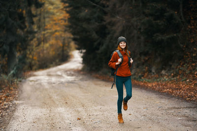 Full length portrait of young woman on road