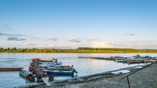 Boats moored at shore against sky