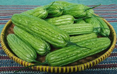 Close-up of green chili peppers in basket on table