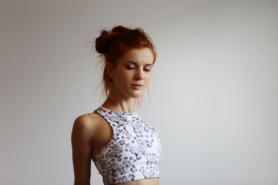 Beautiful young woman with eyes closed against white background