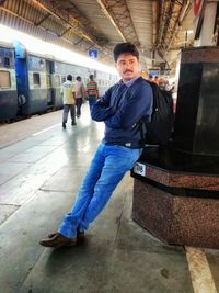 Portrait of man standing at railroad station