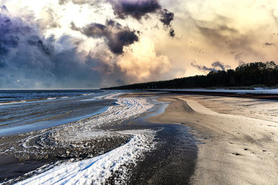 Scenic view of beach against sky during winter