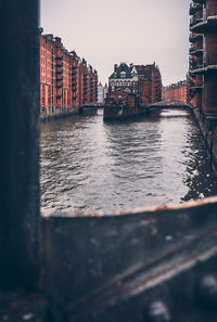 Canal amidst buildings against sky in city