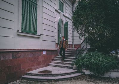 Young man walking on staircase of built structure