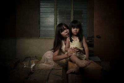Mother and daughter sitting on floor