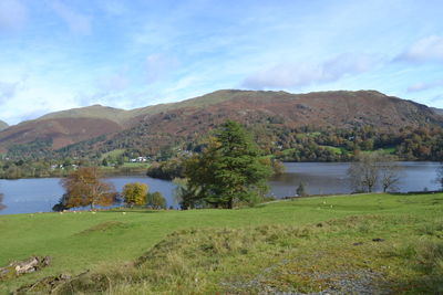 Scenic view of lake by mountain against sky