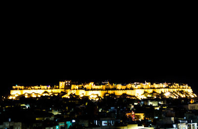 High angle view of illuminated buildings against clear sky at night