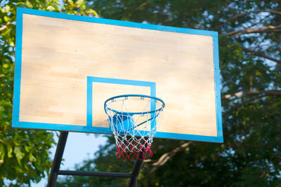 Close-up of basketball hoop against trees