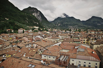 Townscape and mountains against cloudy sky