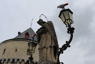 Low angle view of sculpture on street against sky