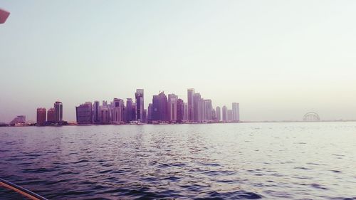 City at waterfront against clear sky