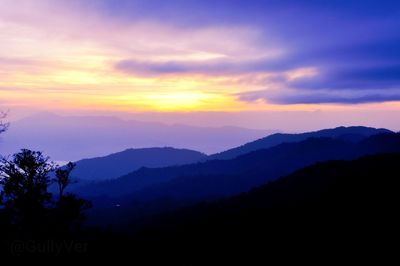 Scenic view of silhouette mountains against sky at sunset