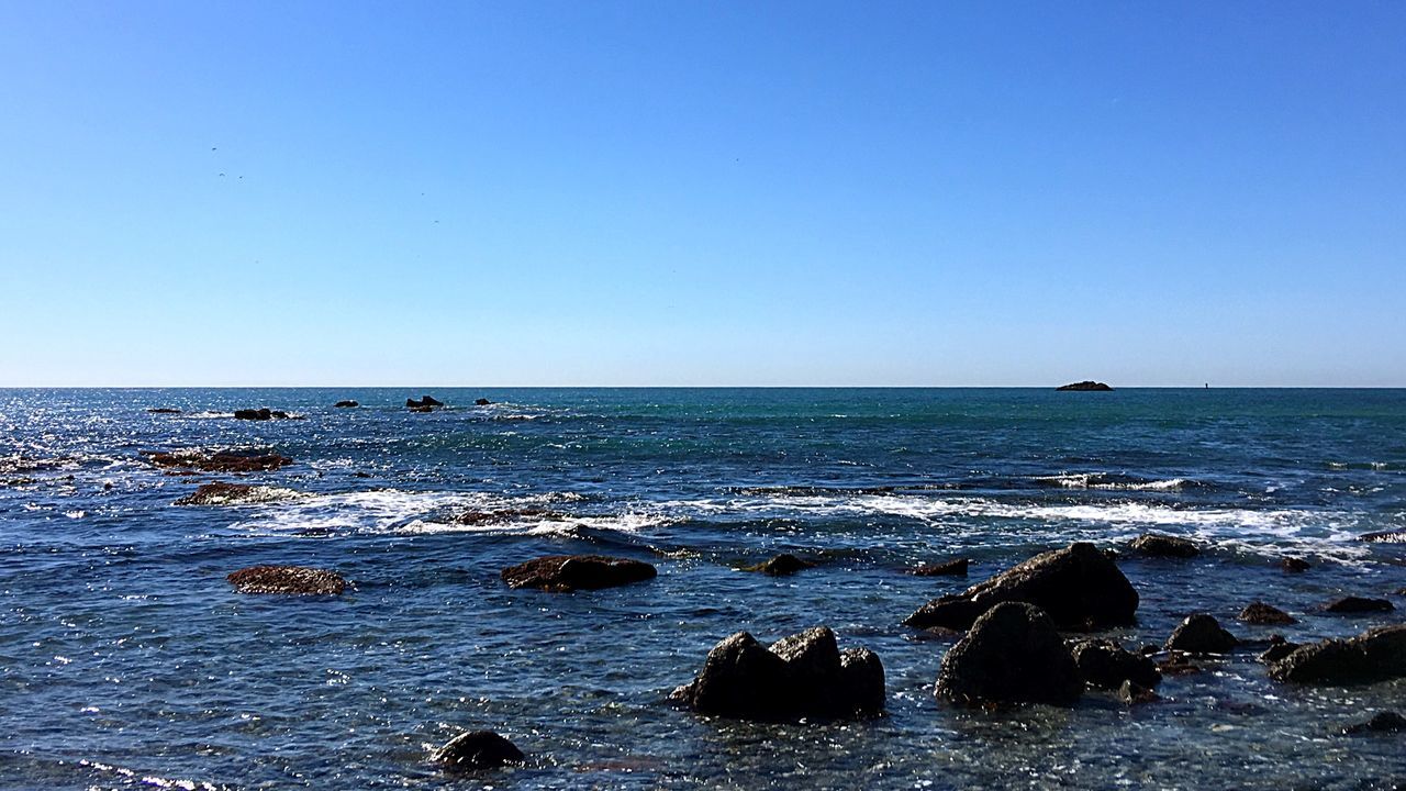 sea, water, clear sky, horizon over water, copy space, blue, scenics, tranquil scene, beauty in nature, tranquility, nature, waterfront, seascape, idyllic, rippled, beach, wave, rock - object, shore, calm