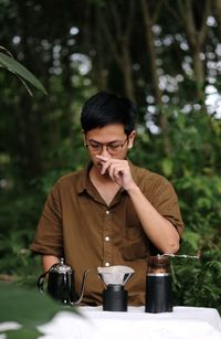 Young man drinking coffee while sitting on table