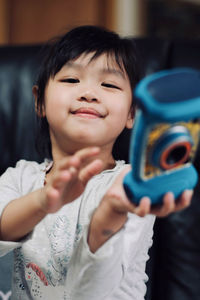 Portrait of cute girl with toy at home