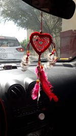 Close-up of red decoration hanging in car