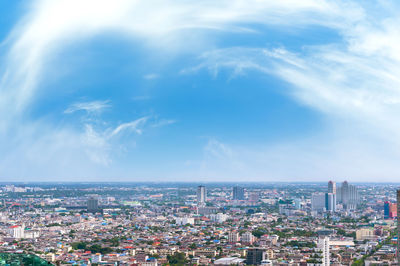 High angle view of city buildings against cloudy sky