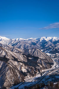 Scenic view of snowcapped mountains against blue sky