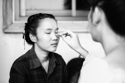 Artist applying make-up to woman