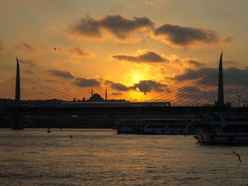 Bridge over sea against sky during sunset