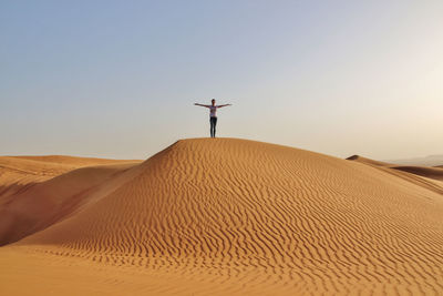 View of woman in desert against clear sky