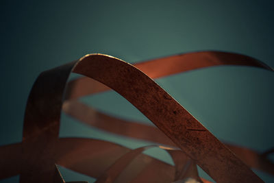 Close-up of metallic structure against blue sky