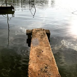 High angle view of wooden post in lake against sky