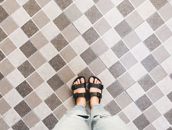 Low section of woman standing on tiled floor