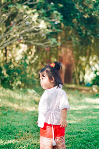 Side view of young woman standing on field