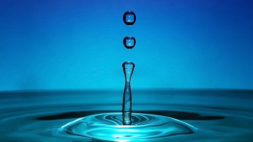 Close-up of water drop on blue surface