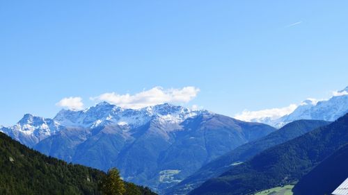 Scenic view of mountains against blue sky