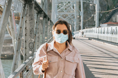 Portrait of woman wearing sunglasses while standing in city