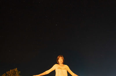 Portrait of woman against sky at night