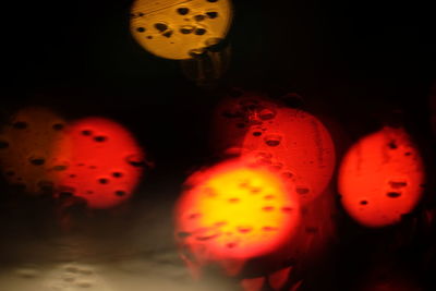 Close-up of water drops on glass against black background