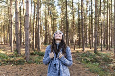 Young woman standing in forest