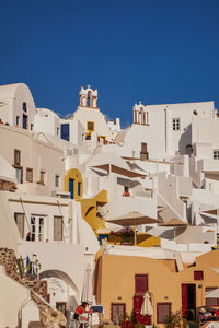 Buildings in city against clear blue sky
