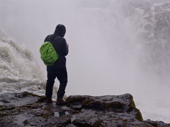 Rear view of man standing on rock