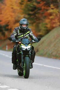 Side view of man riding motorcycle on road