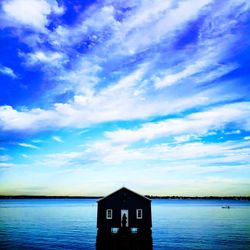 Built structure by sea against blue sky