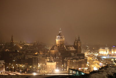 Illuminated cityscape against sky at night