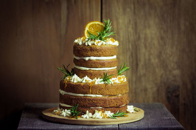 Cake on wooden table against wall