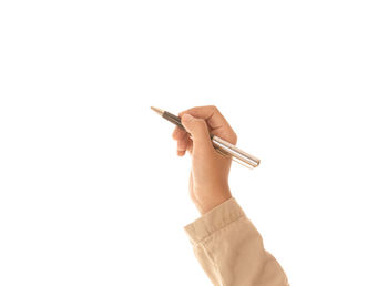 Close-up of hand holding cigarette against white background